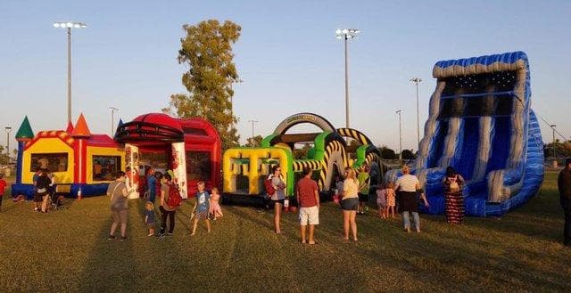 Families and children gathered near bounce houses and inflatable slides